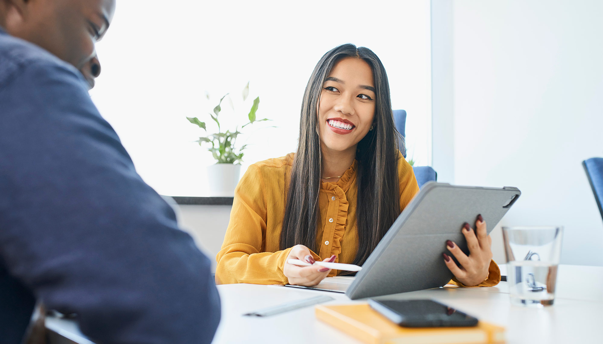 Woman in optometry office using tablet device with male colleague, practice management software