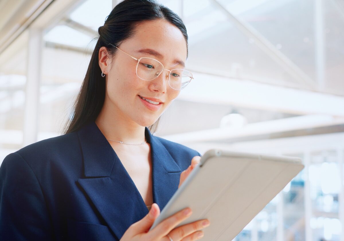 Woman wearing glasses in an office setting holding a tablet, eyewear sales